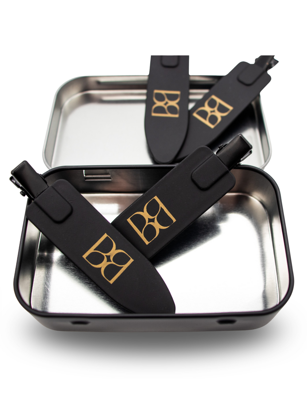 Black hair clips with the BB logo on a metallic tray with a white background