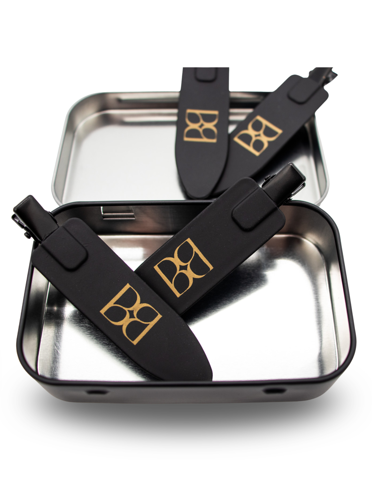 Black hair clips with the BB logo on a metallic tray with a white background