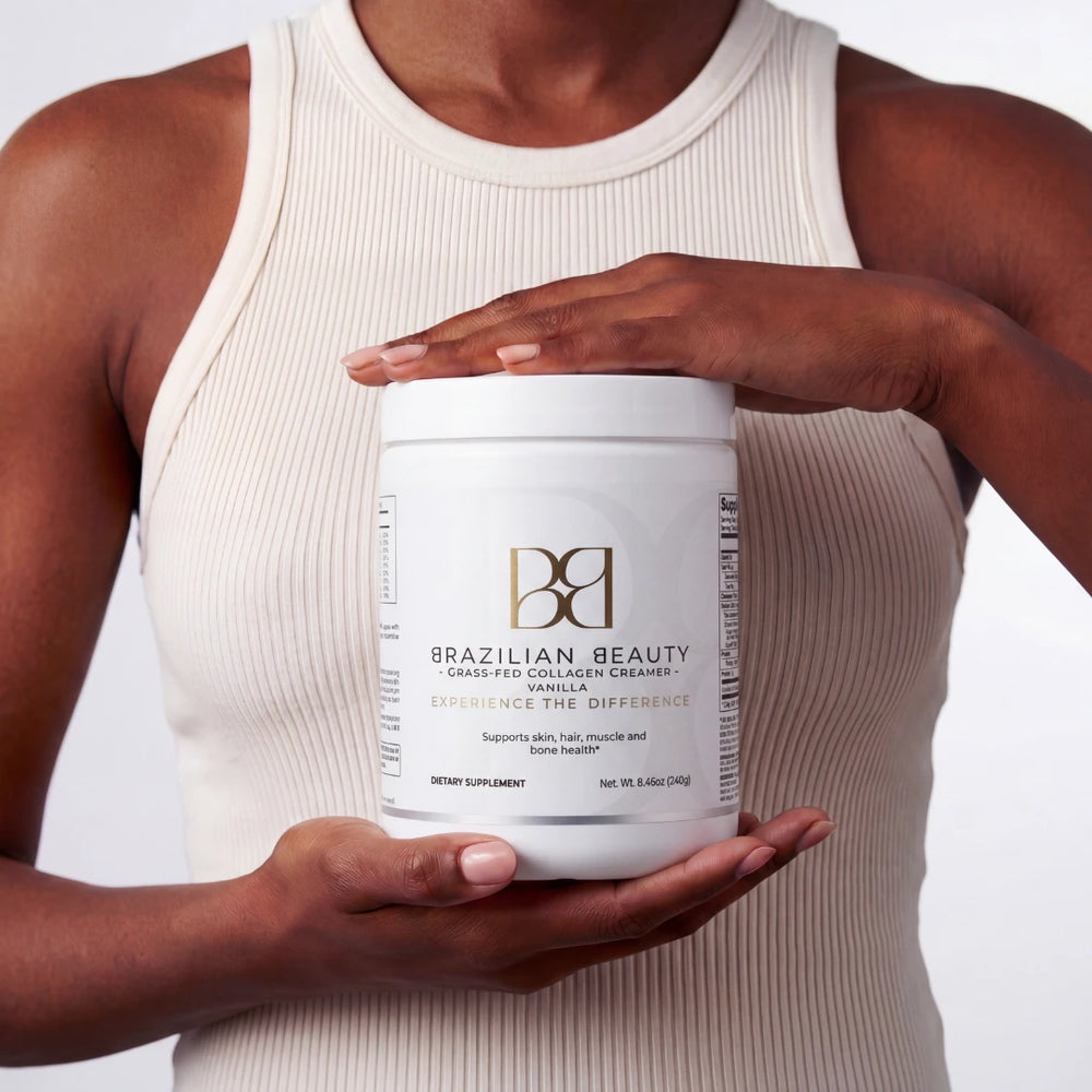 Person holding a container of Brazilian Beauty collagen creamer against a neutral background