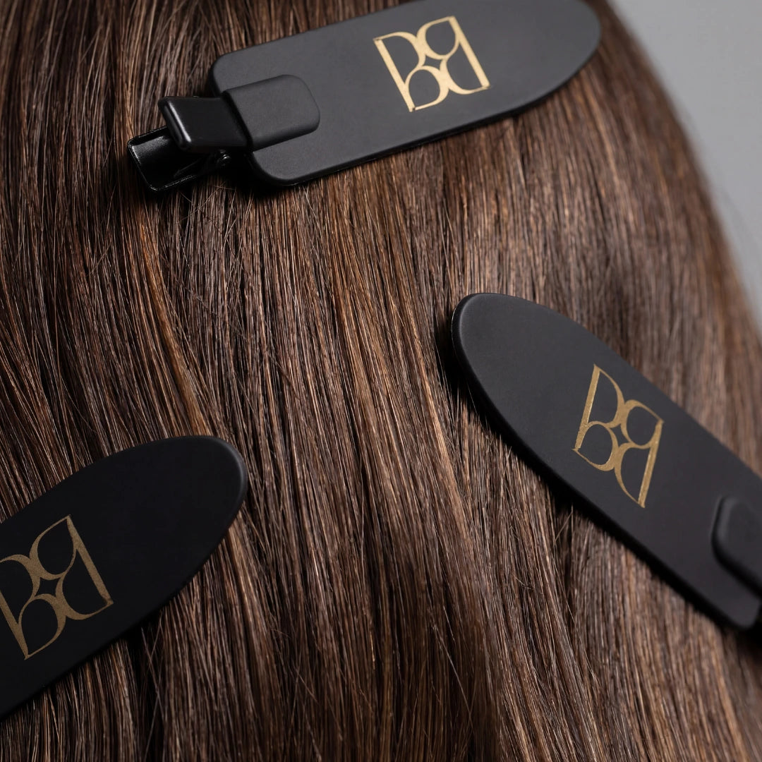 Black hair extensions with BB logo on a a person's hair 