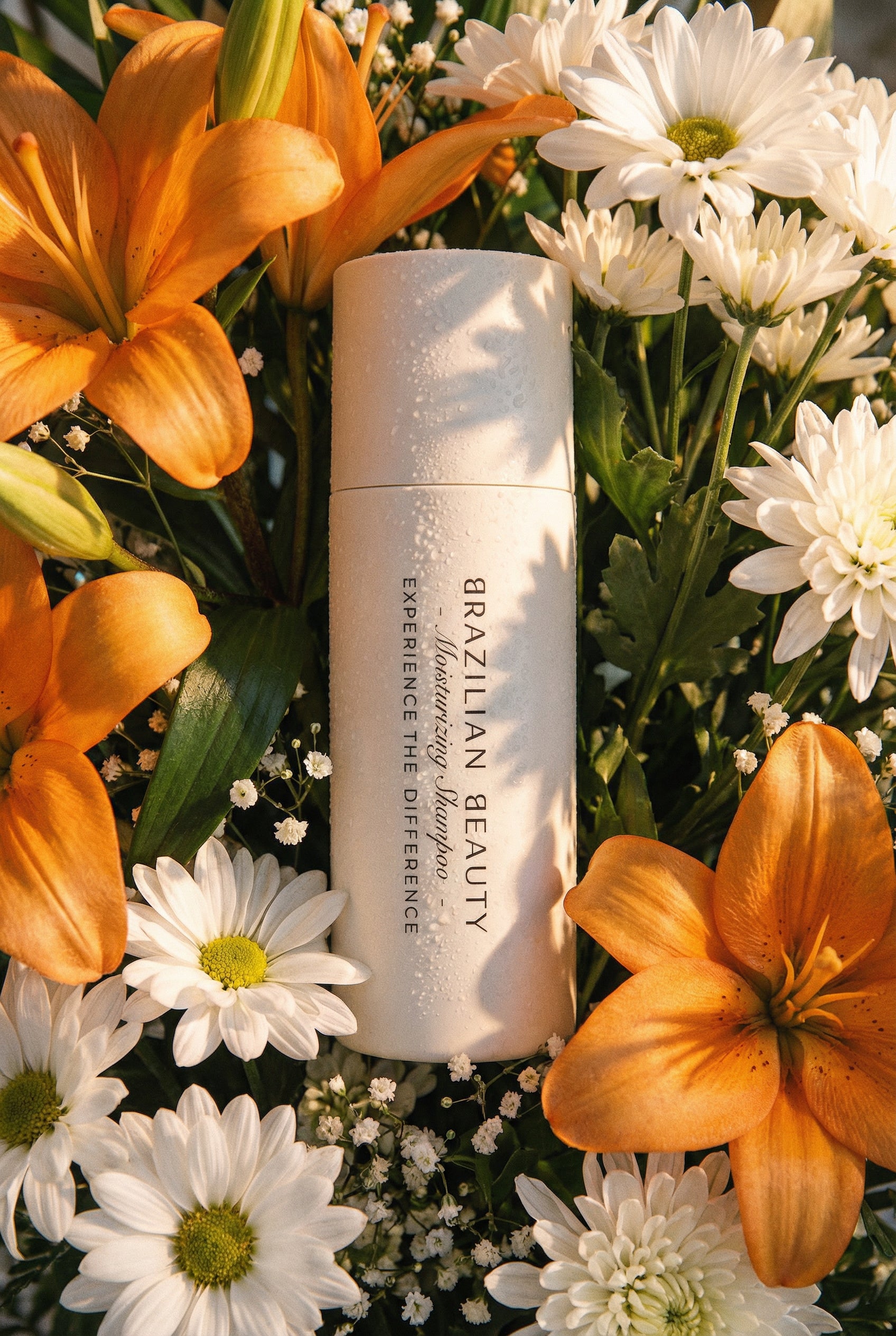 Brazilian Beauty Moisturizing Shampoo on a background of orange and white flowers 